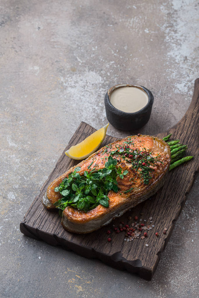 Fried salmon steak with vegetables on wooden board, copy space - Foto, immagini
