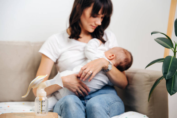 Mom gently looks at the baby and breastfeeds - Valokuva, kuva