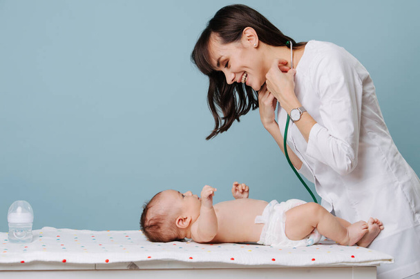Kinderarzt kommuniziert und spielt mit Baby - Foto, Bild