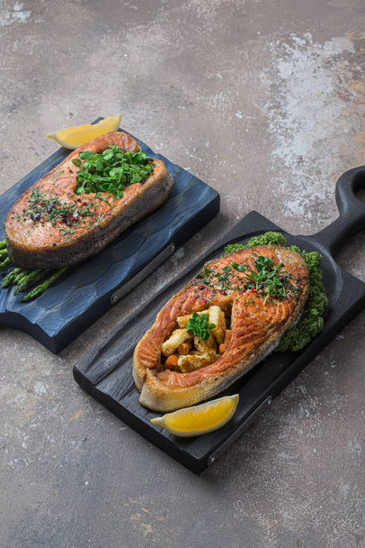 Two salmon steaks with vegetables on wooden boards, copy space - Φωτογραφία, εικόνα