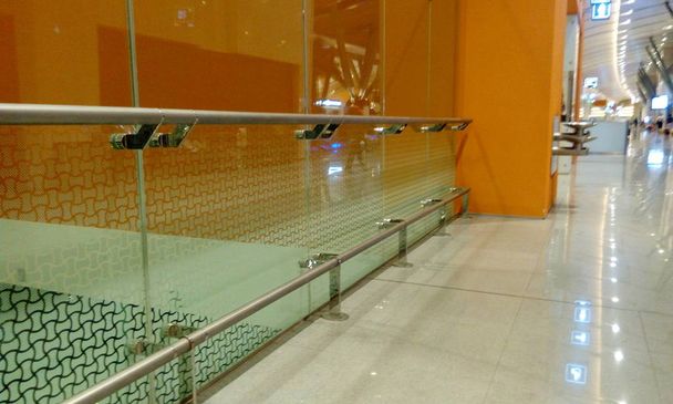 Замороженное стекло Полная высота Стекло перегородка вместе с нержавеющей стали защиты рельсы с оранжевым цветом стен фона
 - Фото, изображение