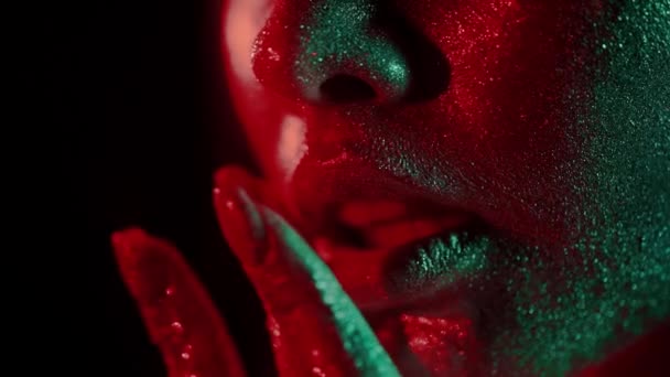 Ritratto di donna che si tocca le labbra con la punta delle dita nei brillantini e nelle luci al neon
 - Filmati, video