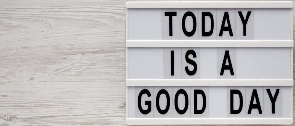 "Σήμερα είναι μια καλή μέρα" λέξεις σε ένα lightbox σε ένα λευκό ξύλινο surf - Φωτογραφία, εικόνα