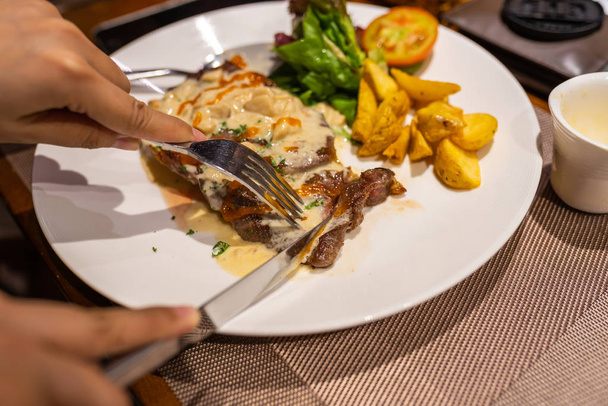 Mani umane con coltello e forchetta taglio delizioso filetto bistecca
  - Foto, immagini