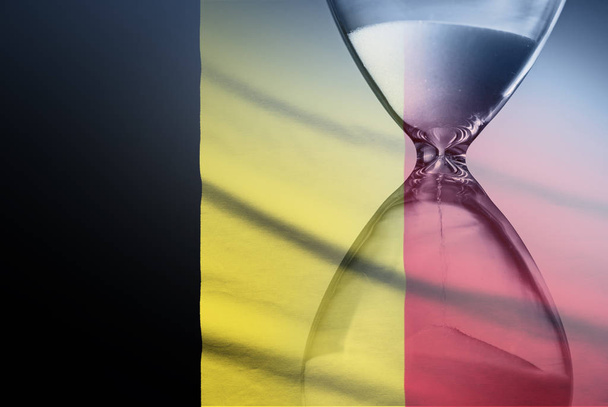 Flag of Belgium with superimposed hourglass conceptual of deadlines - Photo, Image
