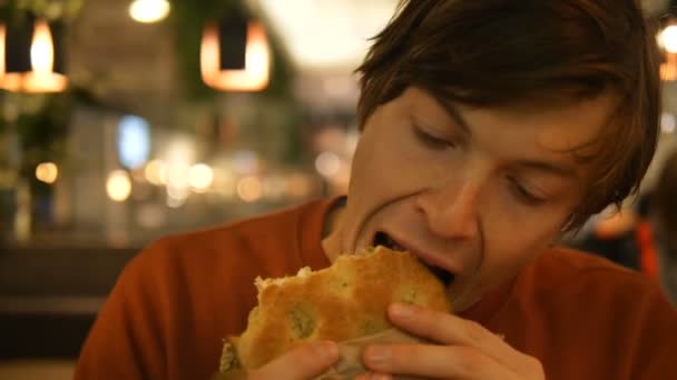 gars en sweat-shirt orange mange des épinards et fromage pain gros plan
 - Séquence, vidéo