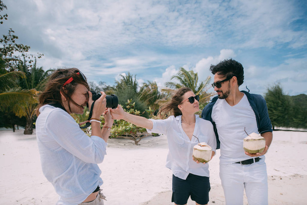 熱帯のビーチで幸せなカップルと写真家. - 写真・画像