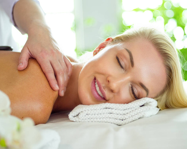 Young woman in spa salon, getting stones massage - Fotoğraf, Görsel