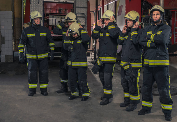 Grupo de bomberos confiados en las armas cruzadas. Fuego - Foto, imagen