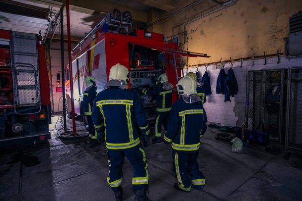 Firefighters preparing their uniform and the firetruck in the ba - Valokuva, kuva