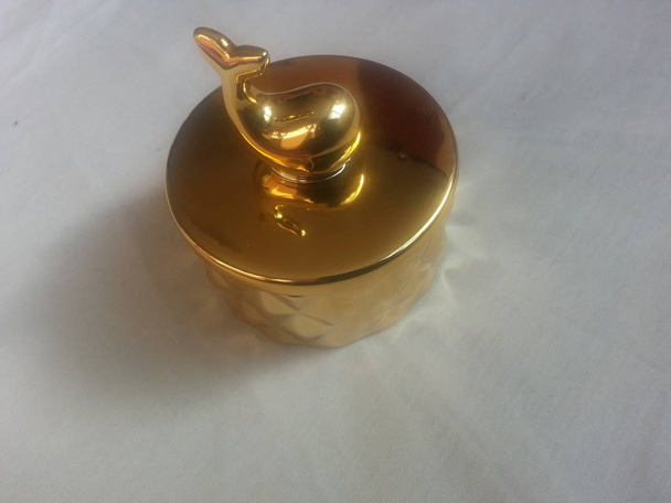 der dekorative kleine goldene Topf mit geöffnetem Delphindeckel, zur Raumdekoration - Foto, Bild
