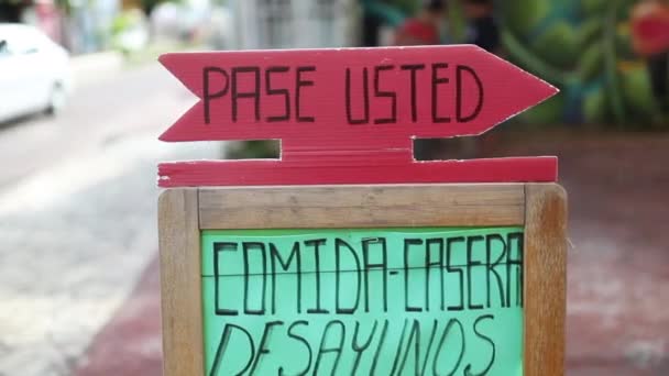 Blick auf ein Schild mit den spanischen Worten "pase usted" vor einem Restaurant - Filmmaterial, Video