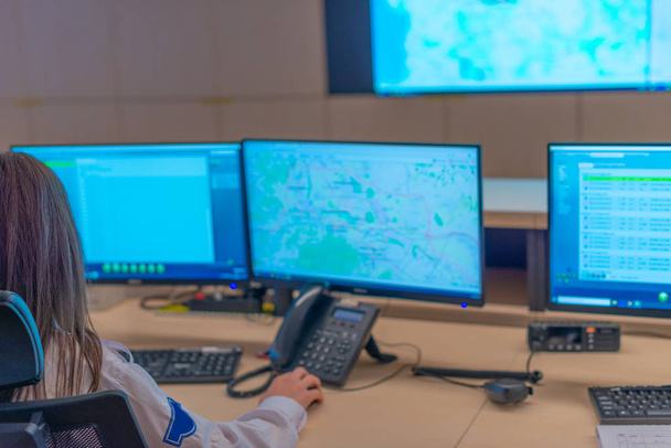 Розмита фотографія охоронців, які працюють на комп'ютерах, сидячи в головному диспетчерському центрі
 - Фото, зображення