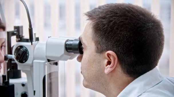 oftalmólogo - un oftalmólogo está revisando la vista de una mujer hermosa usando un aparato especial
 - Metraje, vídeo