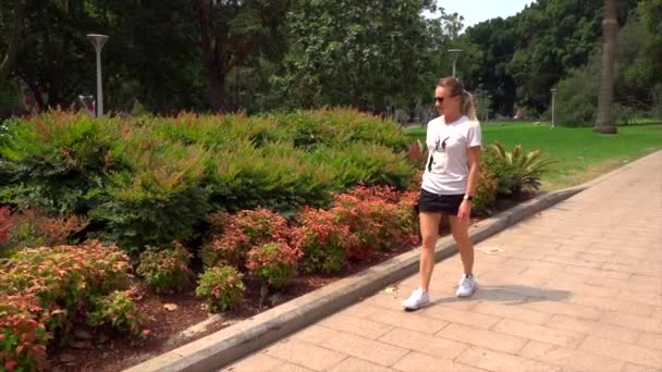 chica camina en un prado verde en el parque - Metraje, vídeo