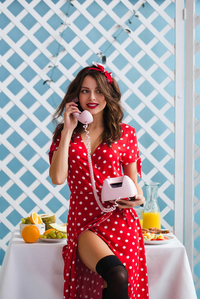 Pin-up girl in a red dress talking on the phone. Juicy colors. Retro style - Fotó, kép