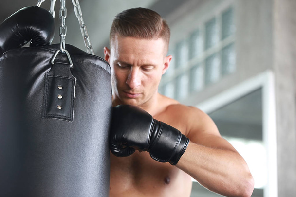 ボクサーの戦いのコンセプト,ヒスパニック系の男は体育館で袋をパンチング,若い男はジムで袋をパンチ使用ボクシング - 写真・画像