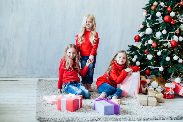 three girls blonde sisters girlfriends gift new year tree holiday Christmas - Photo, Image