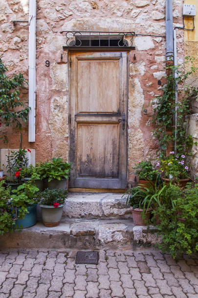 Villefranche-sur-Mer, Franciaország, 2019. október 10. Tipikus provence-i építészet. Az épület homlokzatának töredéke a régi városban. A bejárati ajtó hagyományos kialakítása - Fotó, kép