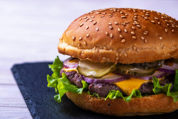 hamburger szalonnával fekete háttér - Fotó, kép