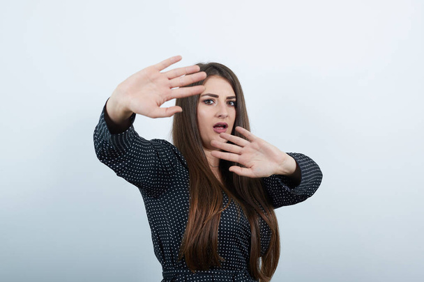 Несчастная молодая женщина показывает ладони в камеру, делает НЕТ, остановите жест
. - Фото, изображение