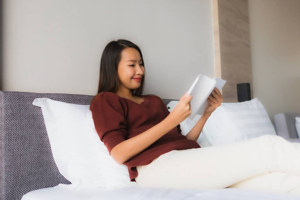 Portret mooie jonge aziatische vrouwen lezen boek op bed - Foto, afbeelding