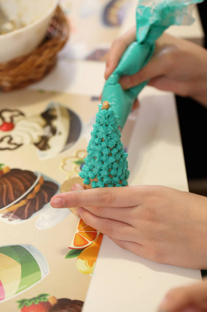 Children's hands make a Christmas tree from cookies. Edible tree - Фото, изображение