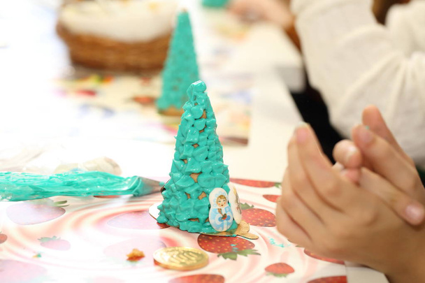 Children's hands decorate a Christmas tree of cookies - Fotografie, Obrázek