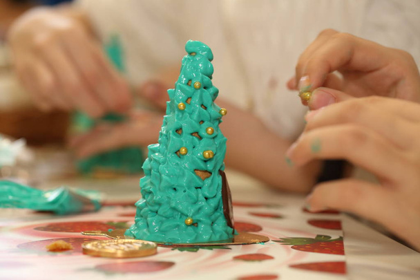 Children's hands make a Christmas tree from cookies. Edible tree - Photo, image