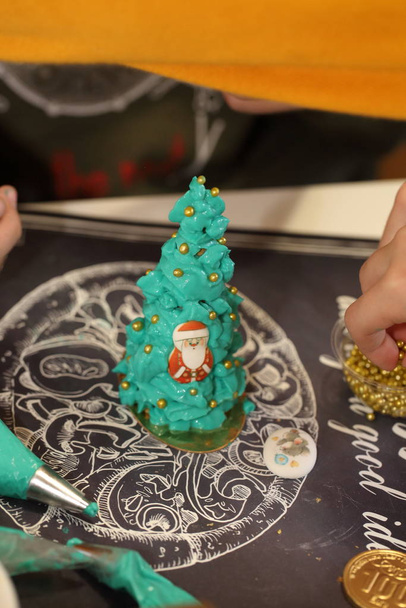 Children's hands decorate a Christmas tree of cookies - Фото, изображение