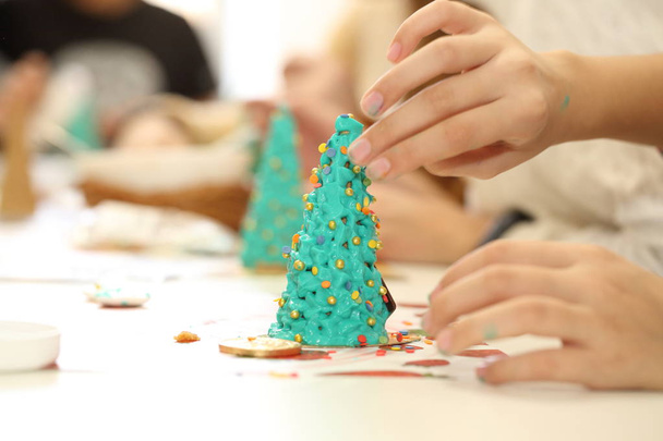 Children's hands with a filling for Christmas baking - Foto, imagen