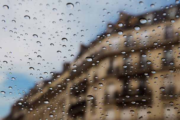 City street seen through rain drops on the car window.  - Foto, Imagem