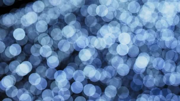 Nieuwjaar 's natuurlijke blauwe wazige gloeilampen op een slinger. Blauwe kerst abstracte lichten bokeh achtergrond - Video