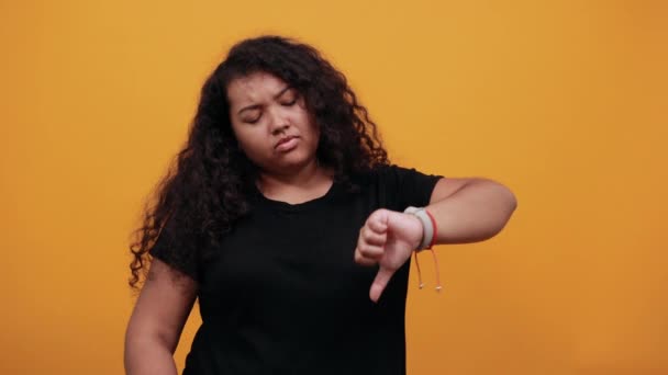 Rozczarowana, kręcona afro-amerykańska młoda dama wskazująca kciuki w górę i w dół. - Materiał filmowy, wideo