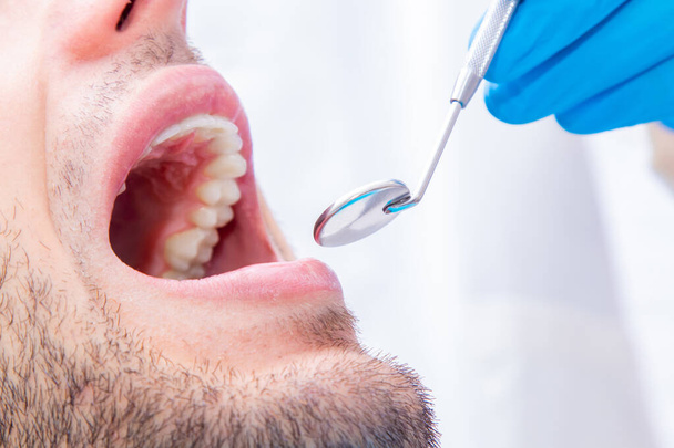 Zahnarzt mit Werkzeugen, die am Mund des Patienten arbeiten - Foto, Bild