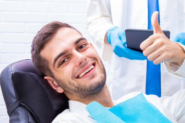 Patient beim Zahnarzt lächelt mit Signal okay - Foto, Bild
