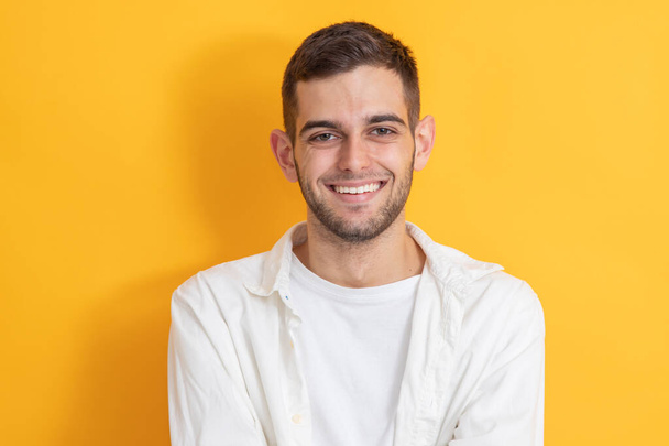 Porträt eines lächelnden jungen Mannes im farbigen Hintergrund - Foto, Bild