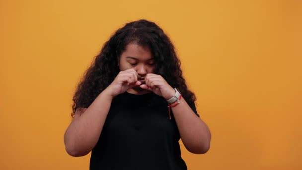 Mujer joven afro-americana triste con sobrepeso manteniendo el puño en los ojos, llorando
 - Metraje, vídeo