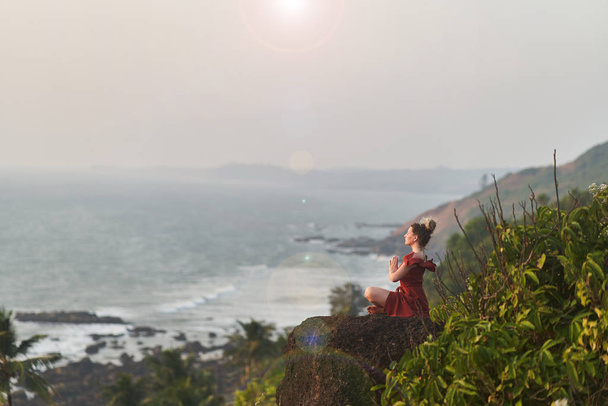 Jeune fille pratique le yoga dans une robe rouge sur une montagne en Inde
 - Photo, image