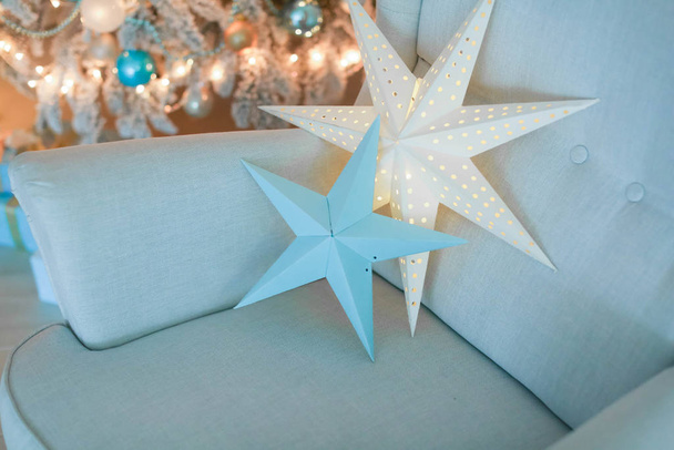 Zbliżenie dekoracji świątecznych z dekoracyjnych kwiatów i prezentów w pudełku leżącym na kanapie - Zdjęcie, obraz
