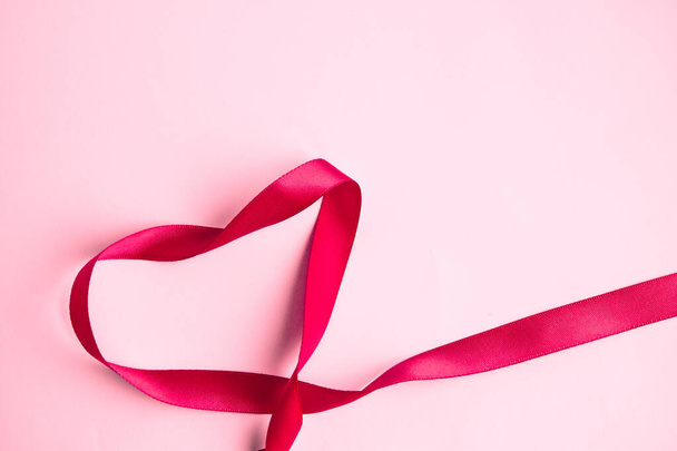 ピンクの背景にハートの形をしたピンクのギフトリボン聖バレンタインデー愛のコンセプト, - 写真・画像