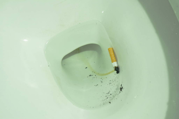  sigarettenfilter drijvend in toilet rioolgat - Foto, afbeelding