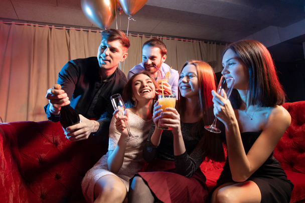 Happy friends girls and boys singing karaoke together in bar - Zdjęcie, obraz
