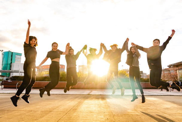 Mladí asijští přátelé skákají při západu slunce. Čínský tým vyhrál - Fotografie, Obrázek