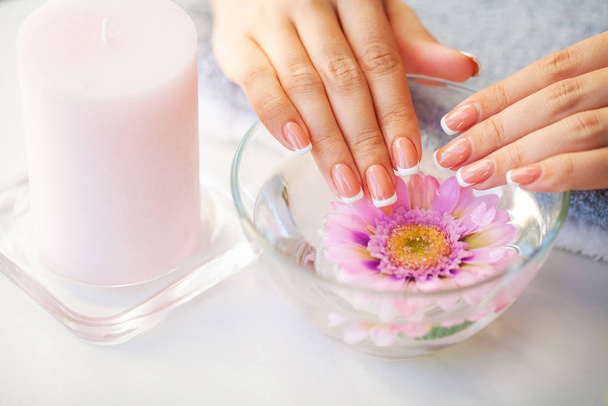 Paznokcie dbają. Piękne kobiety paznokcie z francuskim manicure, w studiu piękności - Zdjęcie, obraz