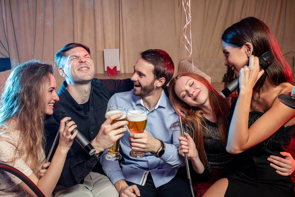 adultos alegres pasan el día libre en el karaoke
 - Foto, Imagen