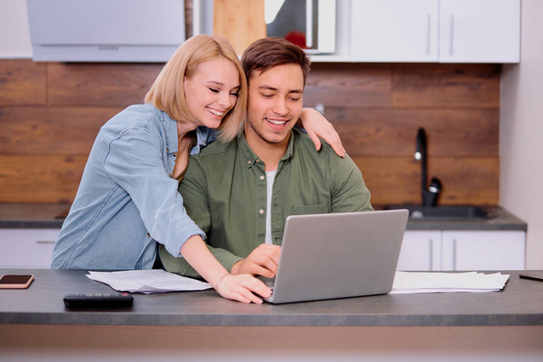 lovely positive couple checking their finance at home - Fotó, kép