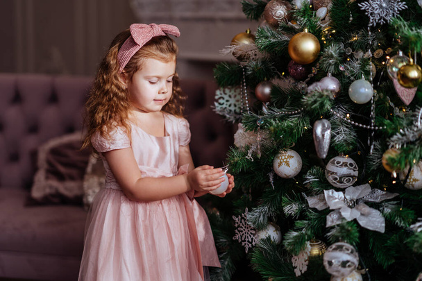 happy child girl near a Christmas tree - Фото, зображення