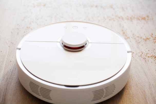 Robot vacuum cleaner performs automatic cleaning of the apartment at a certain time. Smart home. - Φωτογραφία, εικόνα