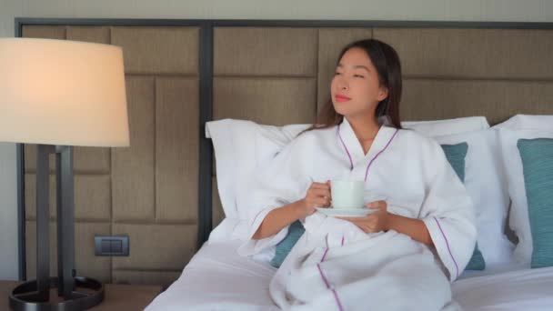 footage of beautiful asian woman with cup of hot drink relaxing at home - Footage, Video